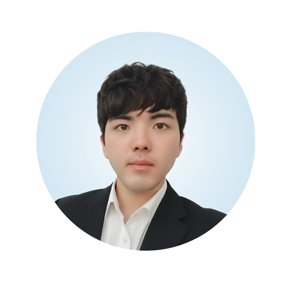 Head-and-shoulders portrait of a man with short black hair, wearing a black blazer over a white collared shirt, against a light blue circular background.